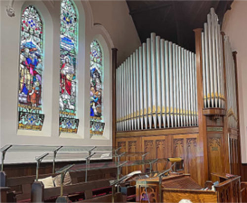 Choir stalls Fincham organ , organpipes and stained glass windows in East Malvern church
