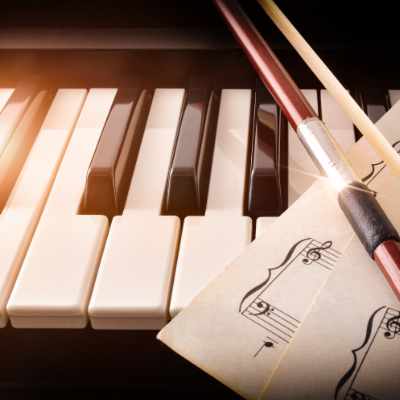 piano keys with music and violin bow for music society victoria concert