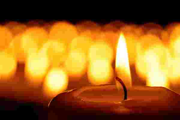 Candle flame in front of many candles